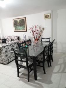 a dining room with a table and chairs and a couch at Hostal Dante in San Gil +13 photos
