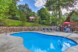 a swimming pool in a backyard with chairs and a table at Romantic Gatlinburg Cabin with Hot Tub and Pool Access in Gatlinburg