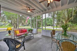 a screened porch with a ceiling fan and chairs at Beaufort Home with Porch, 4 Mi from Downtown! in Beaufort