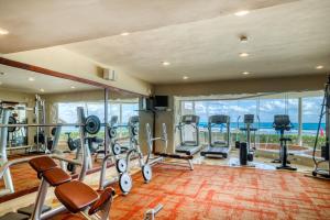 a gym with cardio equipment and a large window at Seashell 334 @ Fishermen in Playa del Carmen