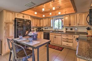 a kitchen with wooden cabinets and a table with chairs at Prescott Cabin with Gas Grill about 10 Min To Downtown! in Prescott