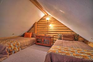 a attic room with two beds and a wooden wall at Soldotna Cabin with Essentials- 4 Mi to Fishing in Soldotna