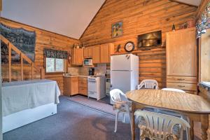 a kitchen with a table and a refrigerator at Soldotna Cabin with Essentials- 4 Mi to Fishing in Soldotna