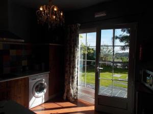 a laundry room with a window and a washing machine at Apartamentos Guidan in Ribadeo