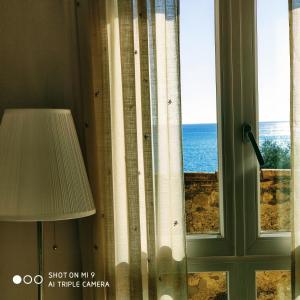 um quarto com uma janela com vista para o oceano em Torre dei Pirati em Letojanni