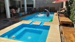un uomo è seduto in una piscina di ABY Hotel a Ramallo