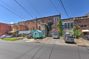 an old brick building with cars parked in a parking lot at Modern Main St Apt in Downtown Waynesville! in Waynesville