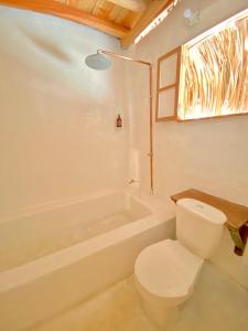 a bathroom with a toilet and a bath tub at Esquina Lejana EcoLodge in Palomino
