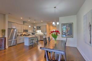a kitchen with a table with a vase of flowers on it at Modern Main St Apt in Downtown Waynesville! in Waynesville