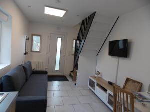ein Wohnzimmer mit einem Sofa und einem TV in der Unterkunft Gite du nuage in Fontenay-Torcy