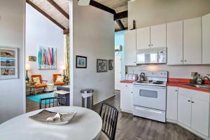 a kitchen with white cabinets and a table and a dining room at Walk to Dewey Beach Bright Condo with Balcony! in Dewey Beach