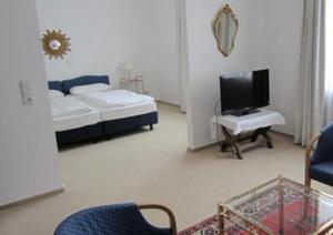 a bedroom with a bed and a tv and chairs at Gildenhof An den Westfalenhallen Dortmund in Dortmund