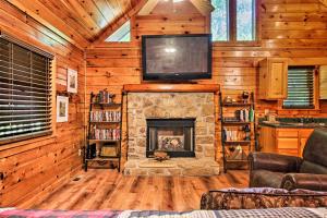 Charming Pigeon Forge Cabin with Private Hot Tub! في سيفيرفيل: غرفة معيشة مع موقد وتلفزيون في الأعلى