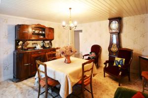 a dining room with a table and chairs and a clock at Du côté de chez Marthe in La Cresse