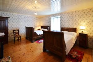 a bedroom with two beds and a wooden floor at Du côté de chez Marthe in La Cresse