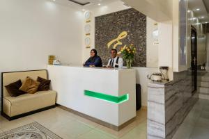 two people standing at a counter in a lobby at Hotel Embassy in Nairobi