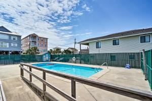 a swimming pool in a yard next to a house at Condo with Balcony and Pool Walk to 2 Beach Accesses! in Carolina Beach