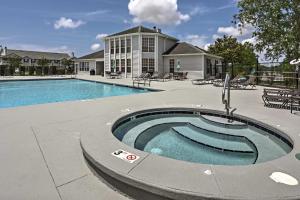 a swimming pool in front of a house at Gulf Shores Condo with Pool Access, 5 Mi to Beach! in Gulf Shores