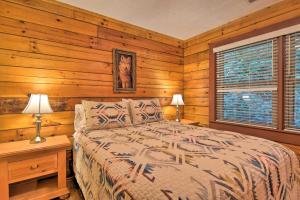 um quarto com paredes de madeira, uma cama e uma janela em Clyde Cabin with Porch - Mins to Smoky Mountains em Clyde