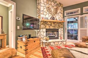 a living room with a stone fireplace and a tv at Screened Porch and 3 Decks Beech Mountain Cabin in Beech Mountain