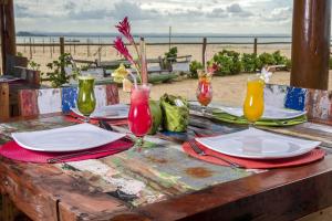 a table with plates and glasses on a table at the beach at Hotel Villa Balidendê in Barra Grande