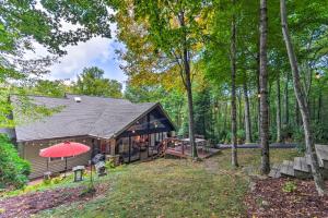a cabin in the woods with a red umbrella at Screened Porch and 3 Decks Beech Mountain Cabin in Beech Mountain