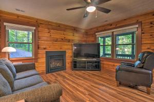 uma sala de estar com um sofá, uma televisão e uma lareira em Clyde Cabin with Porch - Mins to Smoky Mountains em Clyde