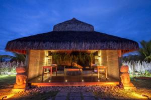 a gazebo with a thatched roof and two chairs at Hotel Villa Balidendê in Barra Grande