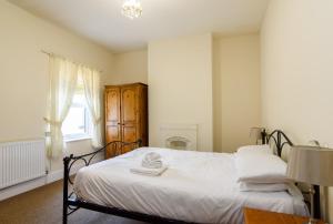 a bedroom with a bed with white sheets and a window at Handpost View in Newport