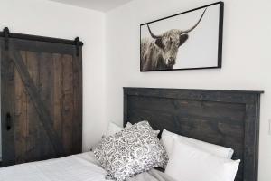 a bedroom with a bed and a picture of a bull on the wall at Cottage by the Lakes with Hot Tub by Lake Nacimiento in Oak Shores