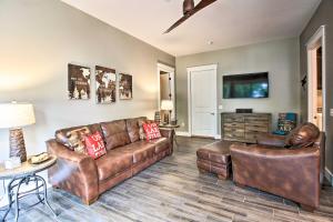 a living room with leather furniture and a flat screen tv at Lakefront Home with Private Dock-15 Mi to Walker in Walker