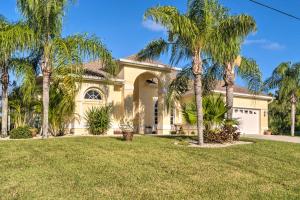 una casa con palmeras delante en Port Charlotte Home on Canal with Lanai and Pool!, en Port Charlotte