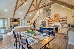 uma cozinha e sala de estar com uma mesa de madeira e cadeiras em Benezette Cabin with Hot Tub, Grill and Mtn Views em Benezette