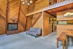 a living room with a couch and a tv and a staircase at half Mi to Hideout Ski Lake Ariel Resort Home! in Lake Ariel