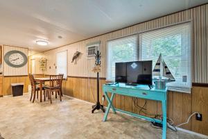 a room with a desk and a table with a computer at Cabin with Fire Pit, Walk to Steinhatchee River! in Steinhatchee