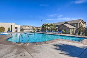 una piscina con tumbonas azules y apartamentos en condominio en St George Area Townhome with Patio and Pool Access, en Washington