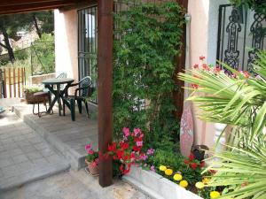 a patio with a table and chairs and flowers at Apartments Luka in Tisno