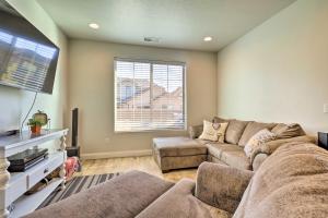 Una sala de estar con un sofá y un televisor de pantalla plana. en St George Area Townhome with Patio and Pool Access, en Washington