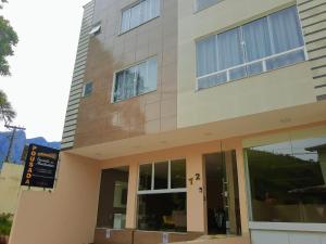 a building with a sign in front of it at Pousada Encanto das Montanhas in Caparaó Velho