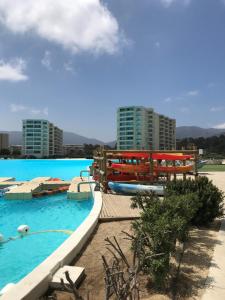 a pool with a water park with buildings in the background at Vista al mar Papudo Crystal Lagoon in Papudo