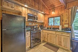 a kitchen with wooden cabinets and a stainless steel refrigerator at Secluded Stanardsville Cabin with 10 Acres and Hot Tub in Stanardsville