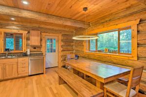 uma cozinha com uma mesa de madeira num chalé de madeira em Custom Riverfront Log Home near Stevens Pass! em Gold Bar