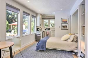 a bedroom with a bed and a kitchen with windows at Menlo Park Studio about 2 Mi to Stanford University in Menlo Park