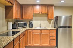 uma cozinha com armários de madeira e um frigorífico de aço inoxidável em CO Springs Apartment Less Than 6 Mi to Garden of the Gods! em Colorado Springs