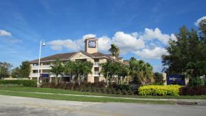 un hotel con una torre de reloj en la parte superior de un edificio en InTown Suites Extended Stay Fort Lauderdale FL, en Tamarac