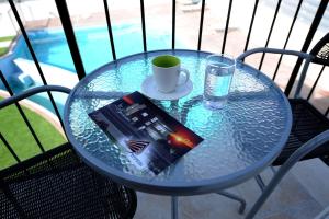 a glass table with a book and a cup on it at Esperando in Maroni