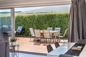 a patio with a table and chairs on a deck at 27 Tuscan in Martinborough 