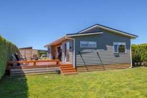 a small house with a porch and a deck at 27 Tuscan in Martinborough 