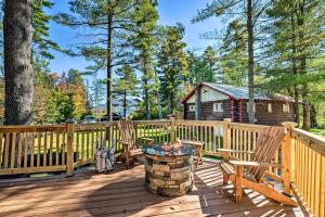 una terraza con 2 sillas y una cabaña de madera en Cozy Speculator Cottage about 2 Miles to Ski Resort!, en Lake Pleasant