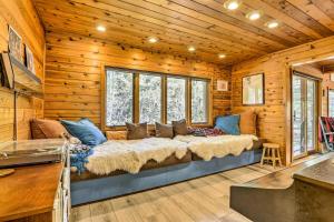 a large bed in a room with wooden walls at Tranquil Dumont Home with Creek and Mtn Views! in Dumont